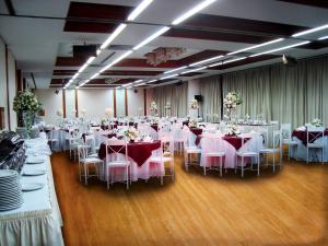 um salão de banquetes com mesas brancas e cadeiras brancas em Nikkey Palace Hotel em São Paulo