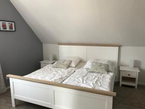 a bedroom with a white bed with two pillows at Ferienwohnung Wansiedler in Sankt Peter-Ording