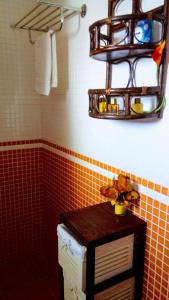 ベラにあるHome Star lllのオレンジ色のタイルの壁と棚が備わるバスルーム