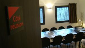 a meeting room with a long table and chairs at Côté Hôtel in Légny