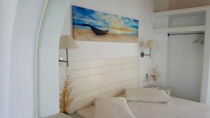 a room with a bed and a painting of a boat at Aegeo Inn in Antiparos