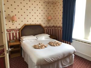 a bedroom with a bed with bows on it at Riviera Hotel in Torquay