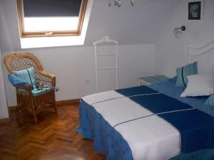 ビラノーバ・デ・アロウサにあるTu Piso en la Playaのベッドルーム1室(ベッド1台、椅子、窓付)