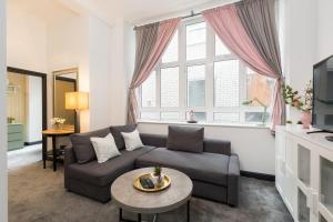a living room with a couch and a table at The Birmingham Manhattan - Urban Living in Birmingham