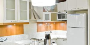 
a kitchen with a refrigerator, stove, microwave and sink at FLAT PRESTIGE SERRA RS 5* in Canela
