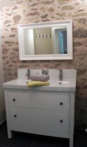a bathroom with a white sink and a mirror at Au Son du Jardin Poitevin in Saint-Laurs