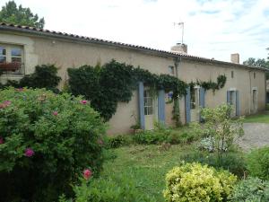 a house with ivy growing on the side of it at Au Son du Jardin Poitevin in Saint-Laurs
