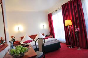 ケルンにあるセラノ シティ ホテル ケルン アム ドームのベッド1台とフルーツ1杯が備わるホテルルームです。