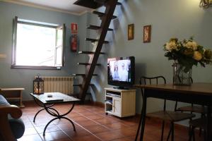 een woonkamer met een televisie en een wenteltrap bij Apartamento La Carreña - La Xiarapina in Serrapio