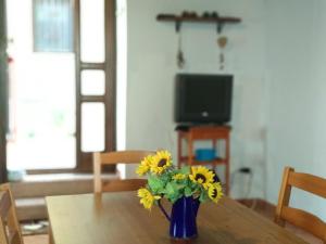 特拉比亞的住宿－Open Space Marianna，摆在桌子上的花瓶,上面装着黄色的花