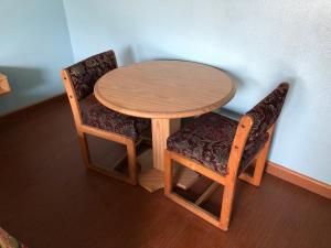 Chester Inn Motel في ستانتون: طاولة خشبية مع كرسيين وطاولة خشبية مع طاولة