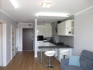 扎莫希奇的住宿－Apartament Hevelius，厨房以及带桌子和沙发的客厅。