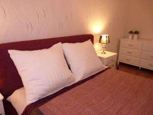 a bedroom with a bed with white pillows and a night stand at Apartament Hevelius in Zamość