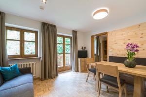 - un salon avec une table en bois et un canapé bleu dans l'établissement Residence Edelweiss, à Anterselva di Mezzo