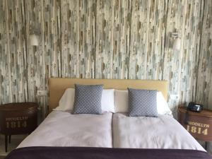 ein Bett mit zwei Kissen in einem Schlafzimmer mit einer Tapete in der Unterkunft Hotel Nómadas in Vejer de la Frontera
