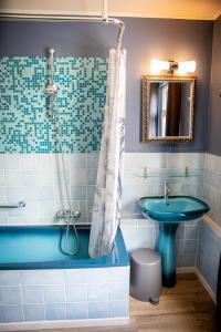 ein Badezimmer mit einer blauen Badewanne und einem Waschbecken in der Unterkunft The White Walker*** in Libin + 40 Fotos