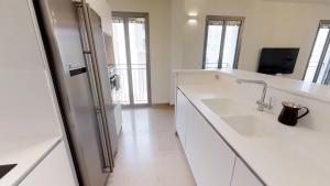 a white kitchen with a sink and a refrigerator at Rental Israel-Mamila Residences 14 in Jerusalem +69 photos