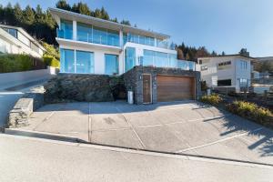 a large house with a garage in a driveway at Remarkable Lake House in Queenstown