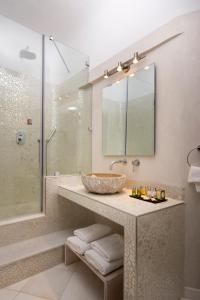 y baño con lavabo y ducha. en Gold Suites - Small Luxury Hotels of the World, en Imerovigli