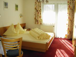 a bedroom with a bed with pillows and a chair at s'Jechlas in Sölden