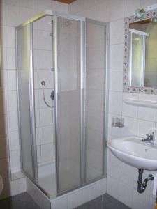 una ducha con una puerta de cristal junto a un lavabo en s'Jechlas en Sölden