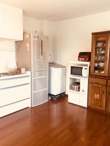 a kitchen with white appliances and a wooden floor at 京都LanLan in Kyoto