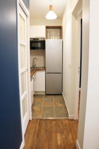 a kitchen with a refrigerator and a tile floor at StayLib - NICE FLAT 2 ROOMS in Asnières-sur-Seine