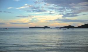 a group of boats in the water at sunset at The Cove in Panwa Beach