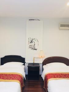 Duas camas num quarto com paredes brancas em 京都LanLan em Quioto