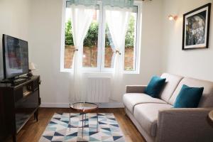 a living room with a couch and a window at StayLib - NICE FLAT 2 ROOMS in Asnières-sur-Seine