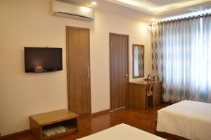 een hotelkamer met een bed en een televisie bij Phu Tho Hotel in Ho Chi Minh-stad