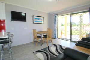 ein Wohnzimmer mit einem Sofa und einem Tisch in der Unterkunft Beachfront 2, 25 Willow Street in Crescent Head