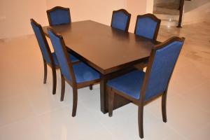Muscat Villa في مسقط: طاولة طعام مع كراسي زرقاء وطاولة