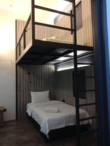 Etagenbett in einem Zimmer mit einem weißen Bett in der Unterkunft The Verve Hotel PJ Damansara in Petaling Jaya