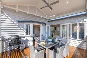 a screened in porch with a table and a grill at Central Cottage in Brisbane