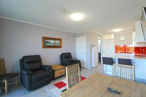 a living room with a table and chairs and a kitchen at Beachfront 4, 25 Willow Street in Crescent Head