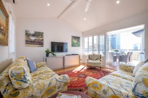 Central Cottage في بريزبين: غرفة معيشة مع أريكة وتلفزيون