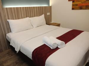 een slaapkamer met een bed met twee handdoeken erop bij The Verve Hotel PJ Damansara in Petaling Jaya