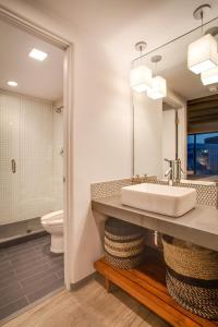 La salle de bains est pourvue d'un lavabo et de toilettes. dans l'établissement El Vado Motel, à Albuquerque