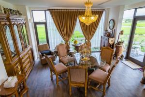 une salle à manger avec une table, des chaises et un lustre dans l'établissement Tata House B&B, à Xingjian