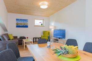 a living room with a table and a tv at Ferienwohnung Hansenbauer in Saalfelden am Steinernen Meer