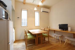 a kitchen and dining room with a table and chairs at Guest House Keiten in Kyoto