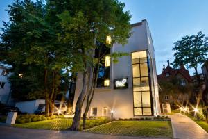 un edificio con un árbol delante de él en Molo Residence en Sopot