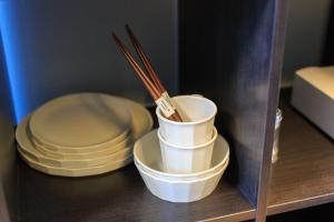 a shelf with plates and chopsticks on a table at Kulton Moct Kenroku in Kanazawa