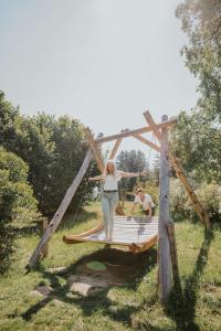 a man and a woman standing on a wooden swing at Hotel Metzgerwirt in Sankt Veit im Pongau