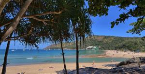 Ein Strand mit einem Haufen Leute im Wasser. in der Unterkunft Mangosteen Ayurveda & Wellness Resort - SHA Plus in Rawai Beach