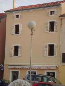a street light in front of a building with windows at Villa Lošinj in Mali Lošinj