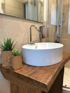 lavabo blanco en una encimera de madera en el baño en Perla della Sila B&B en Lorica