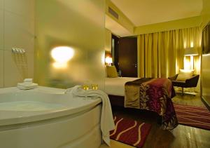 a hotel room with a tub and a bed at Eka Hotel Nairobi in Nairobi