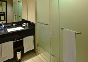 a bathroom with a glass shower and a sink at Eka Hotel Nairobi in Nairobi